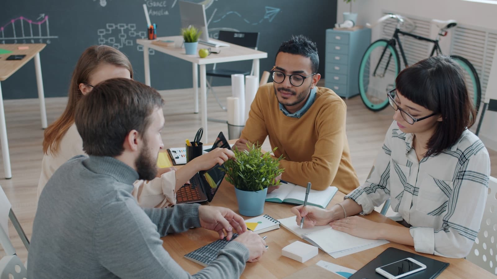 Diverse team collaborates around a table in office